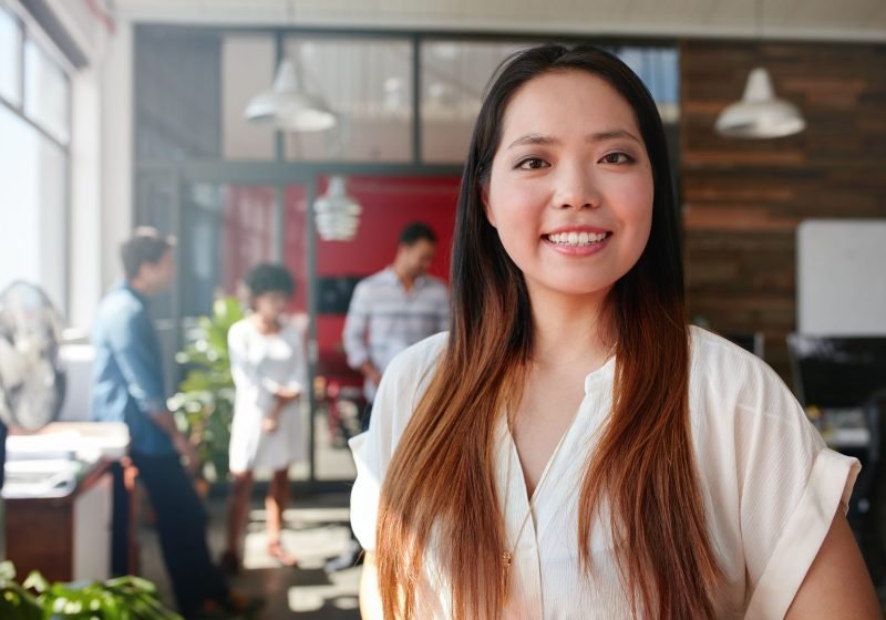 smiling-young-businesswoman-in-office-P7BUN7K-scaled.jpg